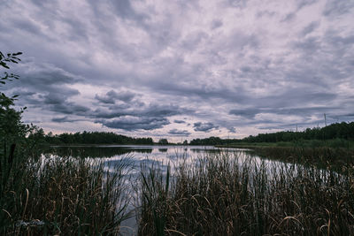 Scenic view of lake against cloudy sky