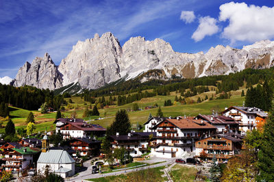 Scenic view of houses and mountains against sky