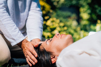 Woman in reiki spiritual healing session. reiki therapist holding hands above heart chakra 