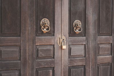 The chinese style door knocker of wooden door at old sino-portuguese at that phanom thailand