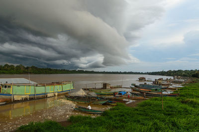 Panoramic view of boats moored on shore against sky