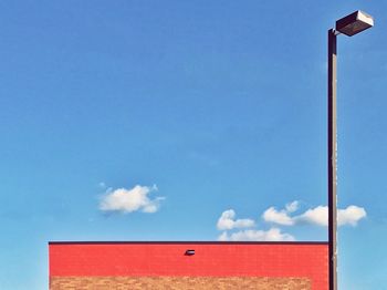 Low angle view of red flag against blue sky
