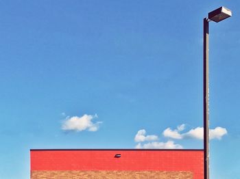 Low angle view of red flag against blue sky