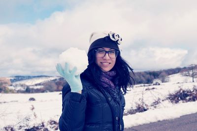 Portrait of smiling young woman standing in snow