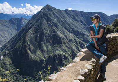 Woman resting on drywall on the inca trail close to machu picchu