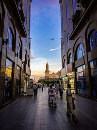 People walking on street amidst buildings in city