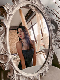 Portrait of young woman looking through window