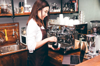 Woman standing by coffee at cafe