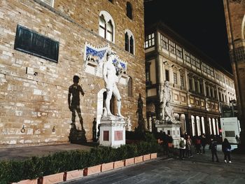 Low angle view of statue against building in city