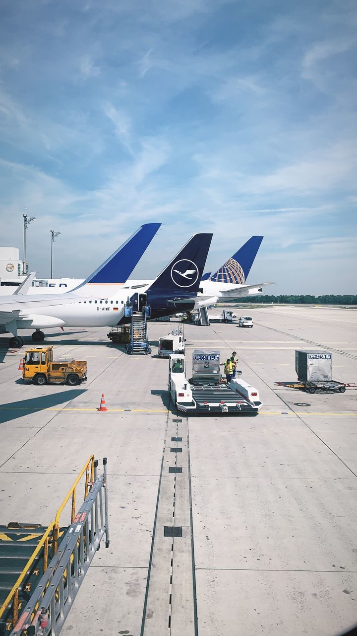 cloud - sky, transportation, sky, airport, airport runway, mode of transportation, day, air vehicle, airplane, land vehicle, nature, stationary, travel, outdoors, incidental people, sunlight, public transportation, technology, runway, aerospace industry