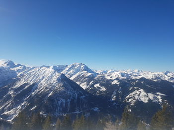 Scenic view of snowcapped mountains against clear blue sky