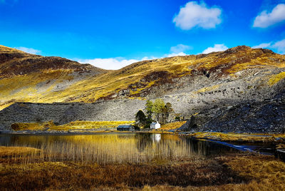 Scenic view of lake by mountain against sky