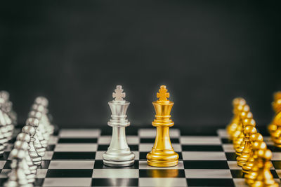 Close-up of chess pieces on board against black background