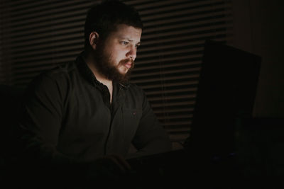 Man using laptop in darkroom