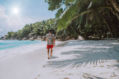 Rear view of man walking on beach