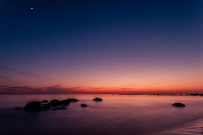 Scenic view of sea against romantic sky at sunset