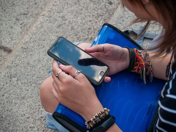 Midsection of woman using mobile phone outdoors