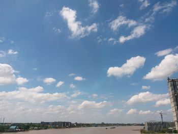 Low angle view of city against cloudy sky