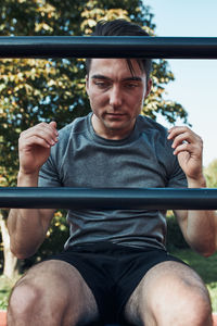 Young man doing sit-ups during his workout in a modern calisthenics street workout park