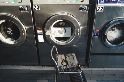 High angle view of ladder by washing machines in laundromat