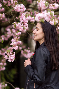 Portrait of young woman standing amidst flowers