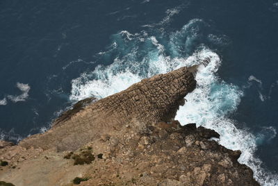 High angle view of waves splashing on rocks