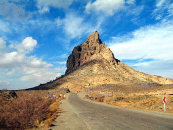 Road leading towards mountain against sky