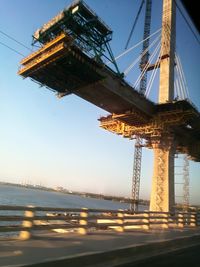 Low angle view of crane against clear sky