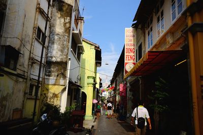 People walking on footpath along buildings