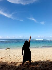 Full length of woman on beach against sky