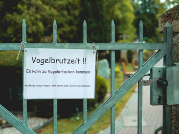 Close-up of information sign on railing