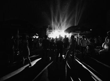 Crowd at music concert against sky at night