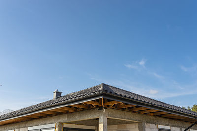 The roof of a single-family house covered with a new ceramic tile in anthracite visible trusses.