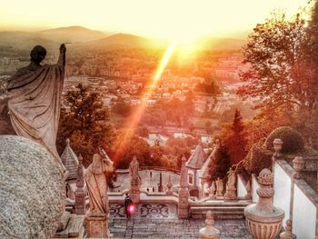 View of buddha statue in city at sunset