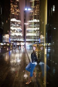 Portrait of smiling woman in illuminated city at night