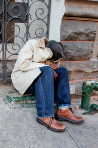 Full length of man sitting on floor in city