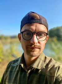 Portrait of man wearing eyeglasses against sky