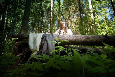 Rear view of woman standing in forest