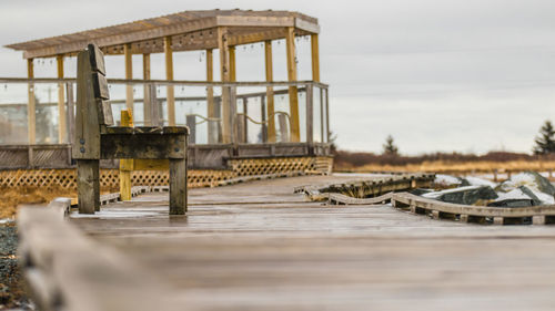 Old pier over lake against sky