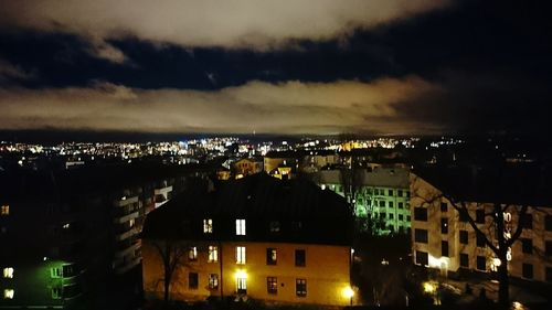 Illuminated cityscape against sky at night