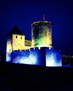 Illuminated building against sky at night