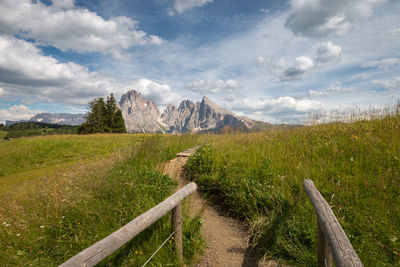 Scenic view of hiking trail with mountains at seiser alm against sky