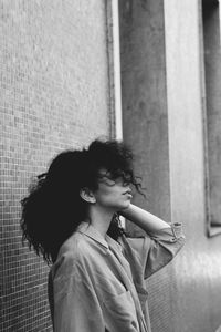 Side view of girl standing against wall