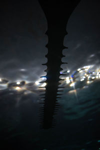 Close-up of illuminated reflection in sea at night