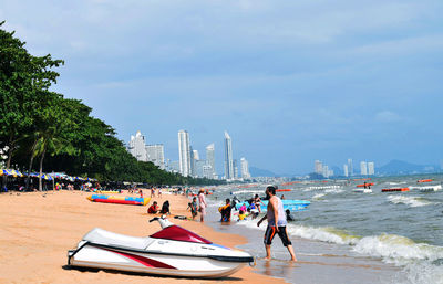 People at beach against sky