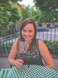 Portrait of a smiling young woman drinking glass