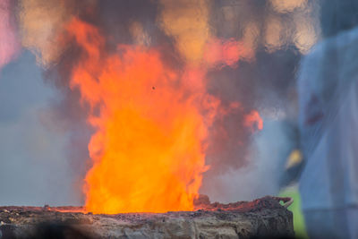 Low angle view of bonfire against orange sky