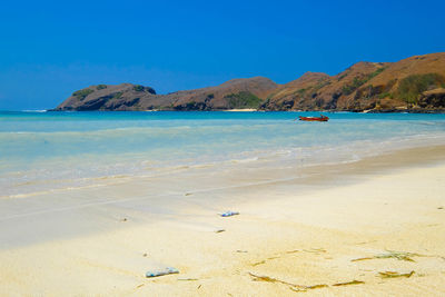 Scenic view of beach against blue sky