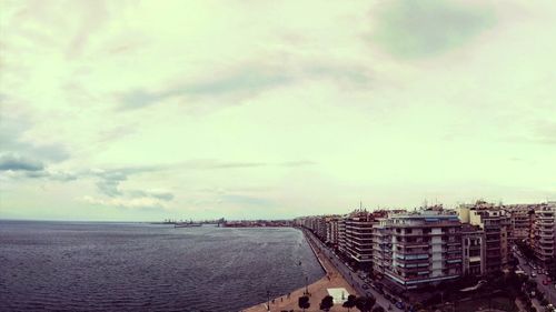 View of cityscape against cloudy sky