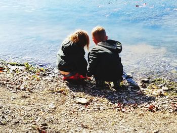 Rear view of couple sitting on beach